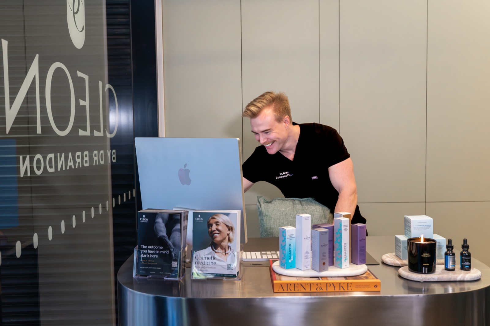 Dr Brandon smiling at the front desk of the Cleon clinic in Potts Point, Sydney