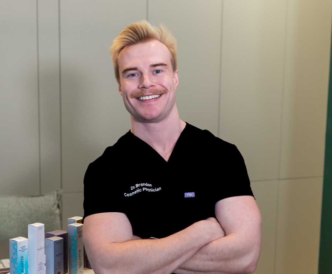 Dr Brandon smiling with his arms folded in the Cleon clinic in Potts Point, Sydney