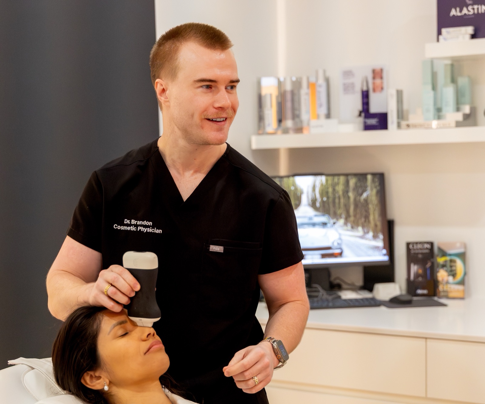 Dr Brandon holding a handheld ultrasound probe to a reclined patient&rsquo;s forehead in the Cleon clinic in Potts Point, Sydney
